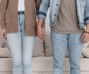 Couple standing side by side holding hands. 