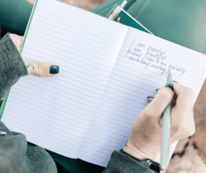 Woman writing in a journal for habits to improve mental health. 