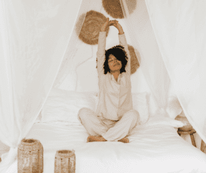 Woman stretching in bed in her PJs.