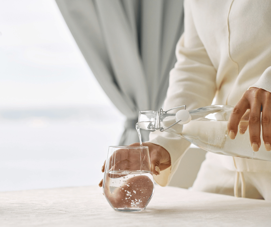 Image of woman filing water cup to show proper hydration to help with migraine relief from morning migraines. 